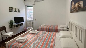 Un dormitorio con dos camas, un televisor, una ventana con vistas y un cuadro en la pared.