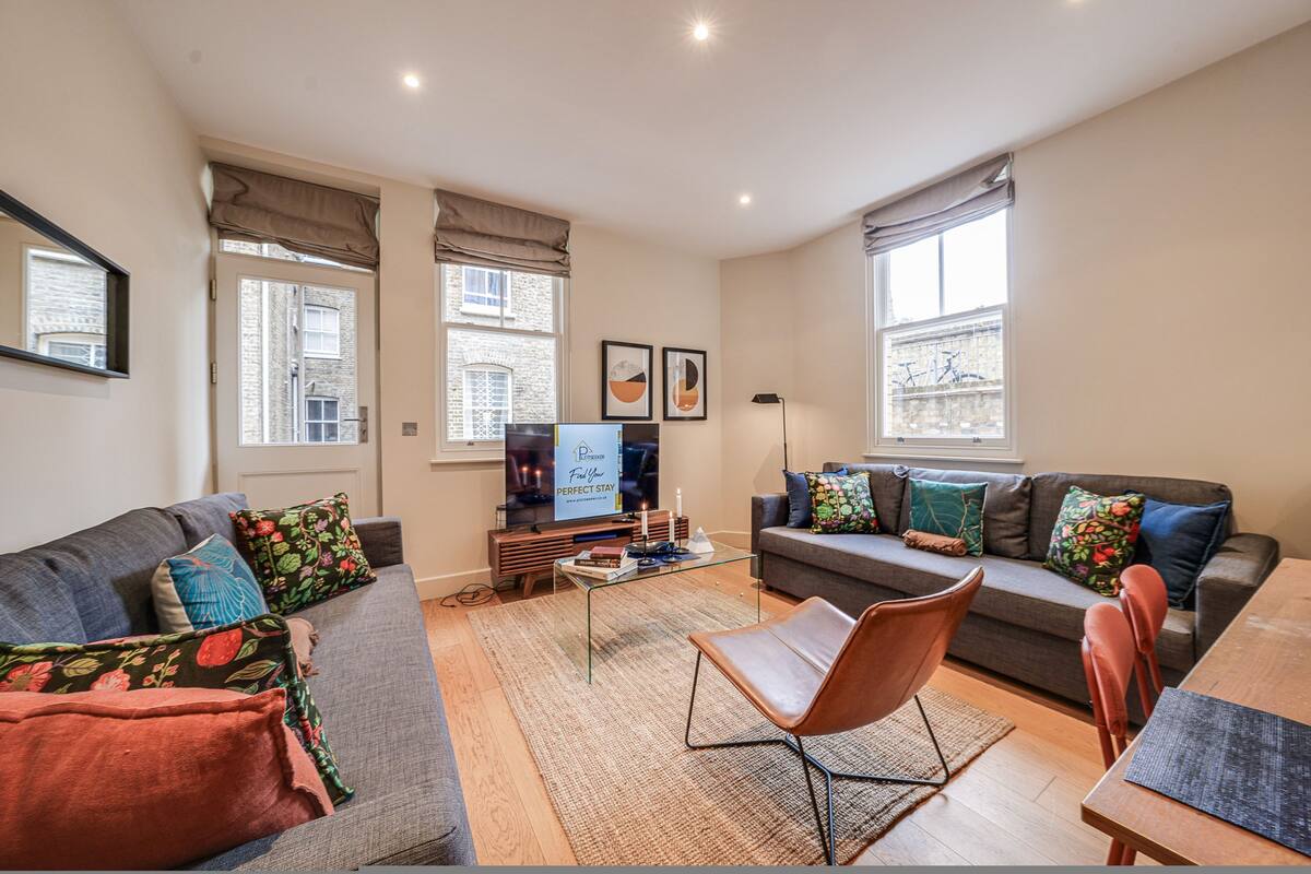 A living room with a sofa, armchairs, a coffee table, and a TV.