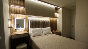 A hotel room with a bed, bedside tables, a mirror, and a wardrobe.