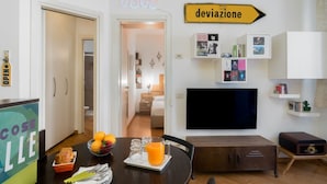 Ein modernes Wohnzimmer mit Essbereich, einem Flachbildfernseher und einem Schild mit der Aufschrift 'deviazione'.