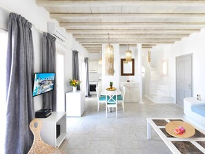 A modern living room with a TV, dining area, kitchen, and a bathroom. - Parfait Luxury Villa Mykonos | Private Pool & Aegean Sea Views (Mykonos)