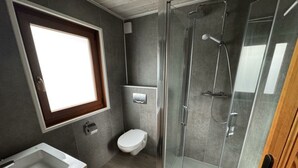 A modern bathroom with a shower, toilet, and sink. - Boekhorst Royal 6 (Susteren)