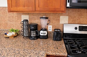 A kitchen with a granite countertop, a coffee maker, a blender, a toaster, and a stove. -  7-bedroom l Penn medicine, CHOP, UPenn, Drexel, Eagles, center city, Uni City (Philadelphia)