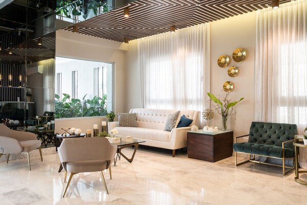 A modern living room with a sofa, armchairs, a coffee table, and decorative elements.