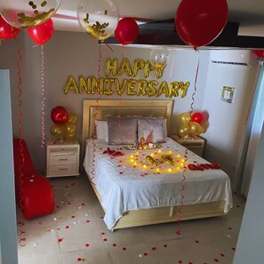 A bedroom with a bed, nightstands, a dresser, and a wall clock.