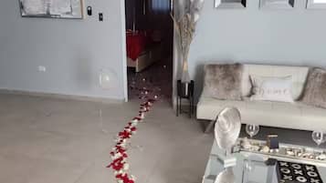 Una sala de estar con un sofá, una mesa de centro y un jarrón decorativo.
