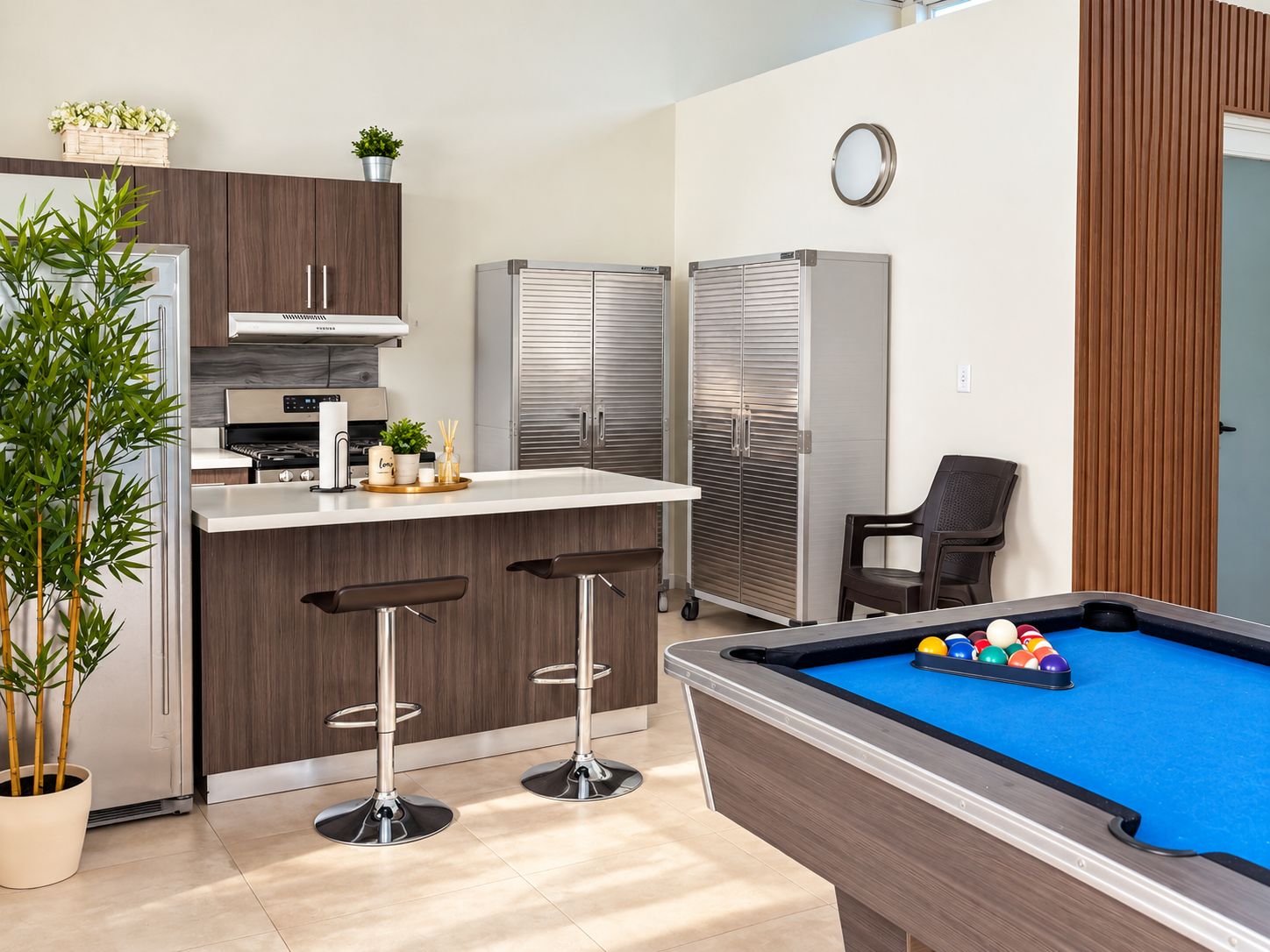 A compact living space with a kitchenette, a pool table, and a seating area.