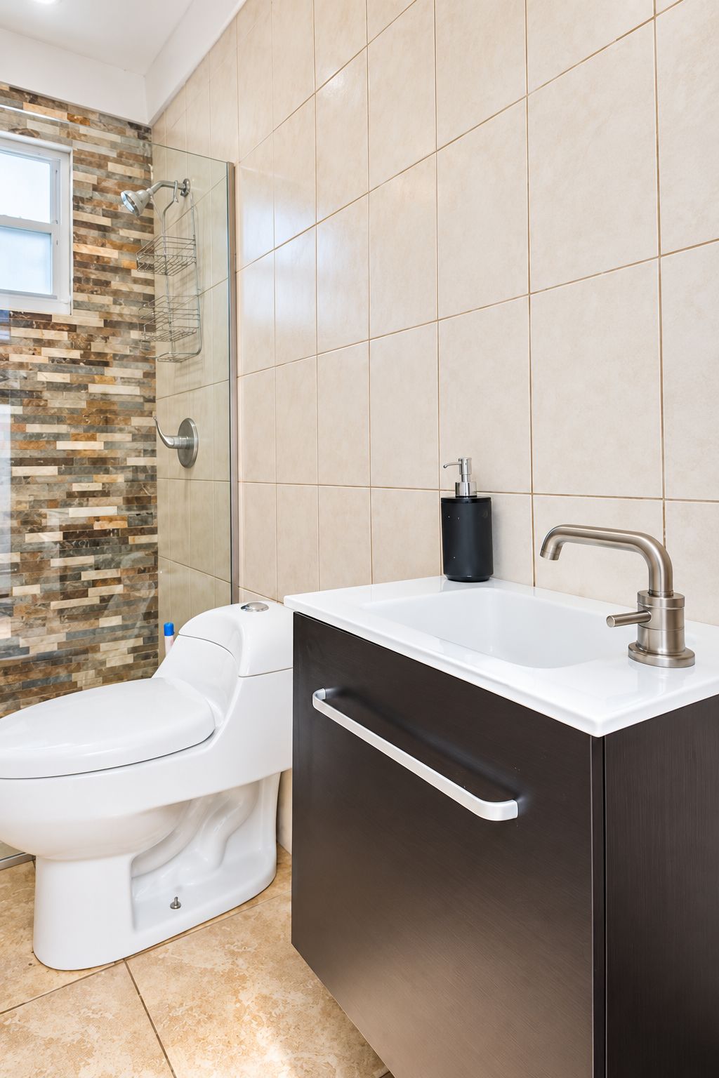 A modern bathroom with a toilet, a sink with a faucet, and a shower area.