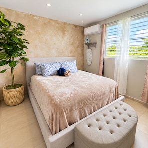 Un dormitorio moderno con una cama grande, una planta en maceta y una ventana con cortinas.