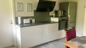 Een moderne keuken met een ingebouwde oven, een koffiezetapparaat en een broodrooster.