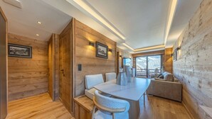 A modern interior with wooden walls, a dining table, chairs, and a sofa. - Walking distance—historic center—sleeps 6 (Megève)