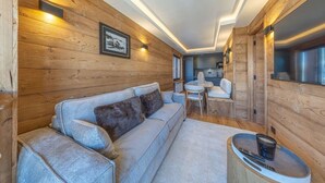 A cozy cabin interior with a sofa, a dining table, and a kitchen area. - Walking distance—historic center—sleeps 6 (Megève)