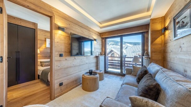 A cozy room with a wooden interior, a sofa, a round table, and a bed. - Walking distance—historic center—sleeps 6 (Megève)