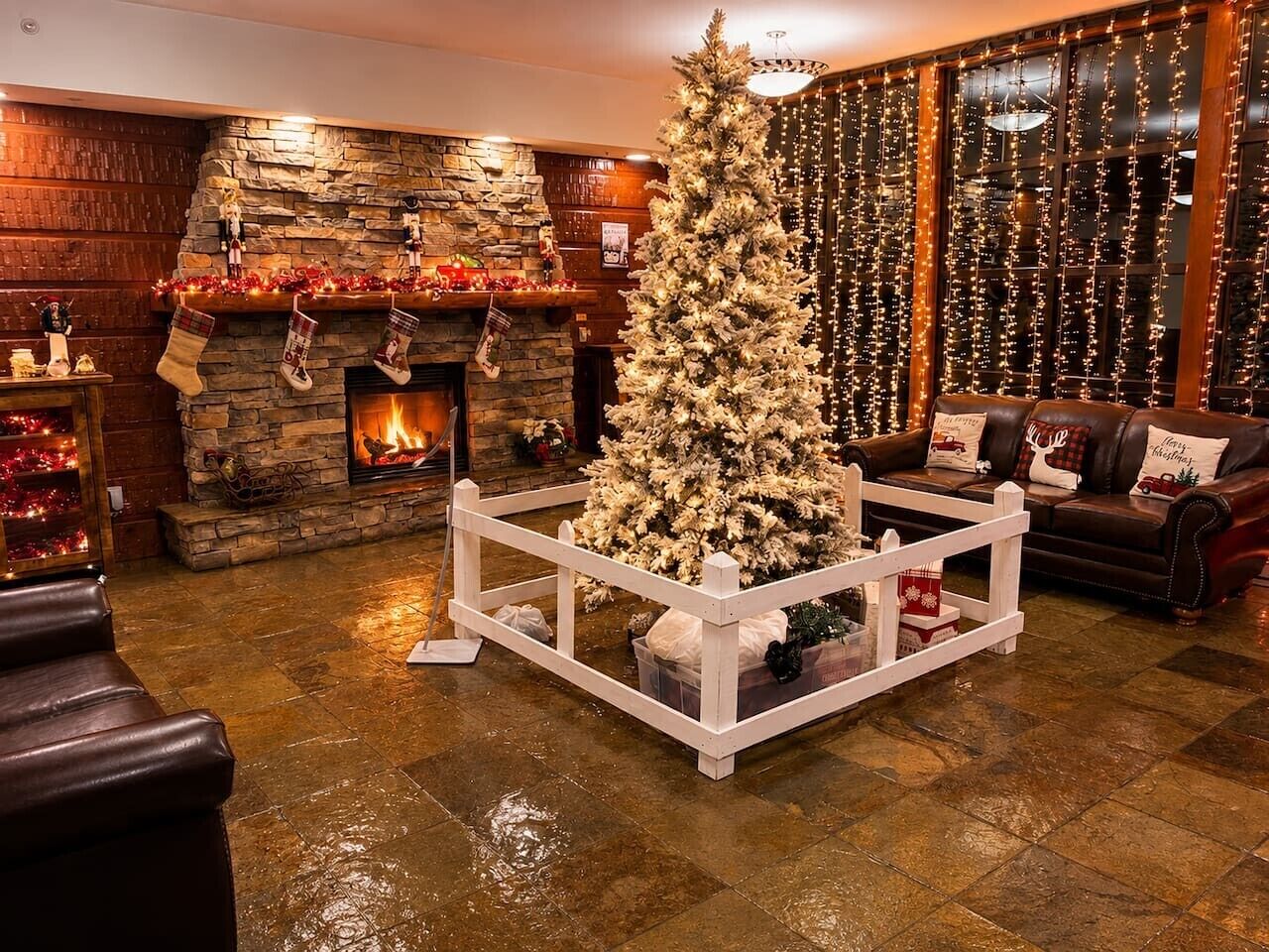 Una sala de estar acogedora con chimenea, un árbol de Navidad y un sofá de cuero.