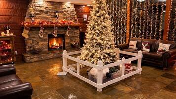 Una sala de estar acogedora con chimenea, un árbol de Navidad y un sofá de cuero.