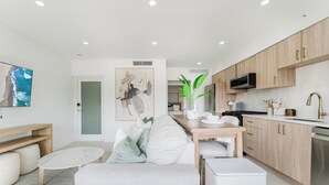 A modern kitchen with wooden cabinets, a microwave, and a sink. - Villa Sirena: Boca Waterfront Escape (Boca Raton)