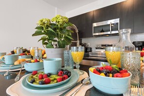 A breakfast setting with fruit bowls, glasses of orange juice, and a potted plant. - 3BR Home Minutes from Disney World (Kissimmee)