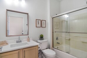 A bathroom with a sink, toilet, and glass-enclosed shower.