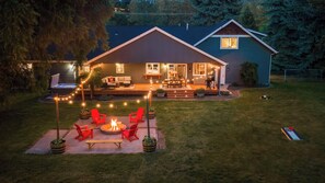Ein Haus mit Terrasse, Sitzgelegenheiten im Freien und einer Feuerstelle.