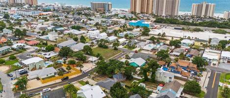 Vista aérea de una zona residencial con casas, carreteras y una playa al fondo.