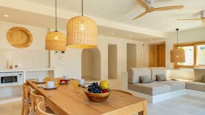 Eine moderne Küche mit Holztisch, hängenden Korblichter und Deckenventilator.
