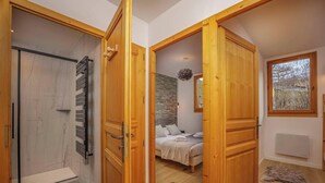 Una camera da letto con un letto, un termosifone e una finestra vista alberi.