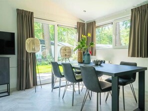 A modern dining area with a table, chairs, and a television. - Hackfort Miva 6 (Maarn)