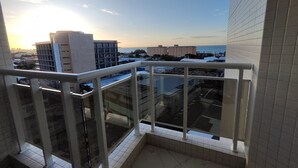 Ein Balkon mit Blick auf Gebäude und einen klaren Himmel.