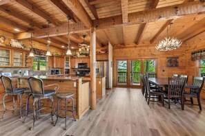 A spacious wooden cabin with a large kitchen, dining area, and a balcony with a view. - Escape to Heaven's Hidden View, a spectacular 6-bedroom, 5-bathroom mountain ret (Sevierville)