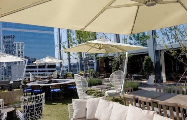 An outdoor seating area with umbrellas, chairs, and tables.