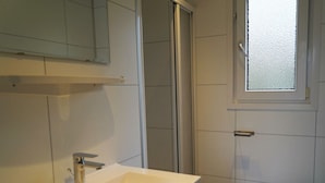 Un baño con lavamanos blanco, inodoro y ducha.