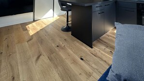 A modern kitchen with a skylight, wooden beams, and black cabinetry. - Stylish BERNHARD Apartment in STRAND HAUS 10 (Borkum)