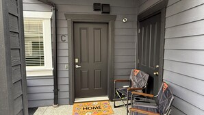 A dark wooden door with a mail slot, a mailbox above it, and a 'C' marking on the wall.