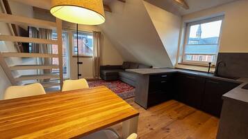 Eine moderne Loftswohnung mit Essbereich, Küche und großem Fenster mit Blick auf die Stadt.