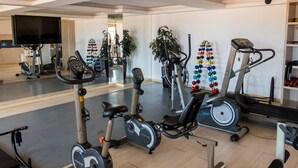 A gym with stationary bikes, an elliptical, and a treadmill. - Beach Village sea View 2 Bedrooms (Fortaleza)
