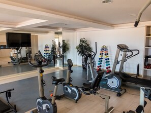 A gym with stationary bikes, an elliptical, and a treadmill. - Beach Village sea View 2 Bedrooms (Fortaleza)