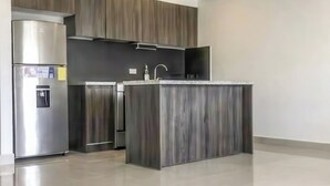 Una cocina moderna con una isla integrada, electrodomésticos de acero inoxidable y muebles de madera.