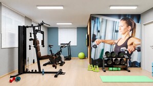 A gym with exercise equipment, a yoga mat, and a wall-mounted TV. - Apartamento Novo 2 Quartos e Vista mar 1001b (Fortaleza)