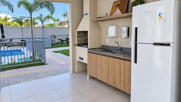 Cozinha moderna com geladeira embutida, pia e um pequeno balcão.