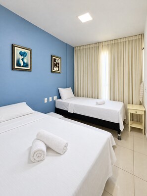 A hotel room with two beds, a bedside table, and a window with curtains. - Cobertura no Golf Ville Deck Privativo com Jacuzzi e Churrasqueira (Aquiraz)