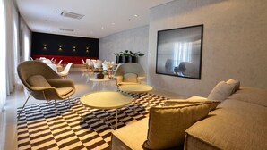 A modern living room with a checkered floor, a large sofa, armchairs, and a coffee table. - Flat 2 Quartos a 50m da Praia Perto da Feirinha (Fortaleza)