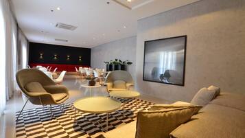 A modern living room with a checkered floor, a large sofa, armchairs, and a coffee table.