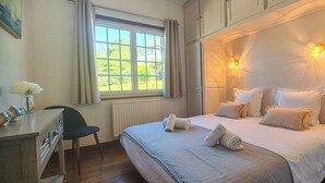A bedroom with a bed, bedside lamps, a window, a desk, and a chair. - Les Embruns - 5-minute walk from the beach - Sleeps 10 - Villerville (Villerville)