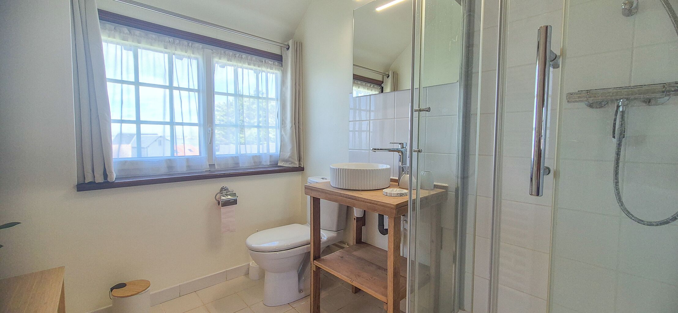 Een badkamer met toilet, wastafel en douche.