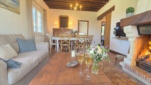 A cozy living room with a sofa, dining table, chairs, and a fireplace. - Les Embruns - 5-minute walk from the beach - Sleeps 10 - Villerville (Villerville)