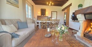 Ein gemütliches Wohnzimmer mit einer Couch, einem Esstisch, Stühlen und einem Kamin.
