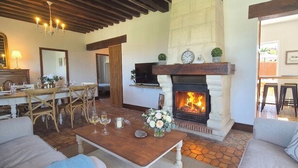 A living room with a fireplace, dining area, and a TV mounted above it. - Les Embruns - 5-minute walk from the beach - Sleeps 10 - Villerville (Villerville)