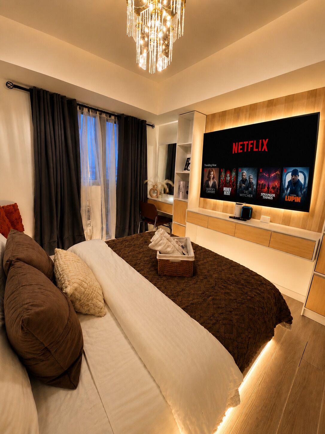 A modern hotel room with a large bed, a flat-screen TV displaying Netflix content, and a cozy seating area.