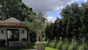 A wooden deck with outdoor seating, a pool, and a house in the background. - Bali-inspired Oasis in the Heart of Winter Park (Winter Park)