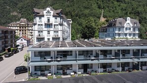 A hotel with multiple floors, balconies, and a parking area. - Charming Alpine Apt with View, 5min to Interlaken Ost (Interlaken)